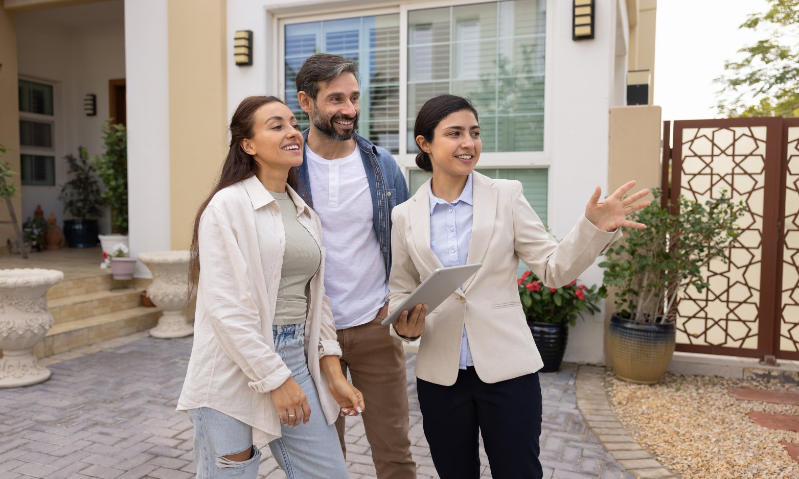 Buyers talking with an estate agent outside a house while comparing Tonbridge and Tunbridge Wells