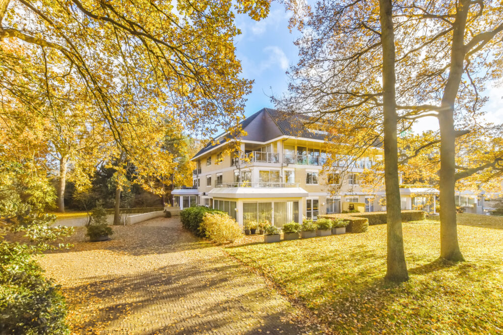 Residential property surrounded by golden autumn trees and fallen leaves, reflecting the autumn property market in Barnet and Enfield.